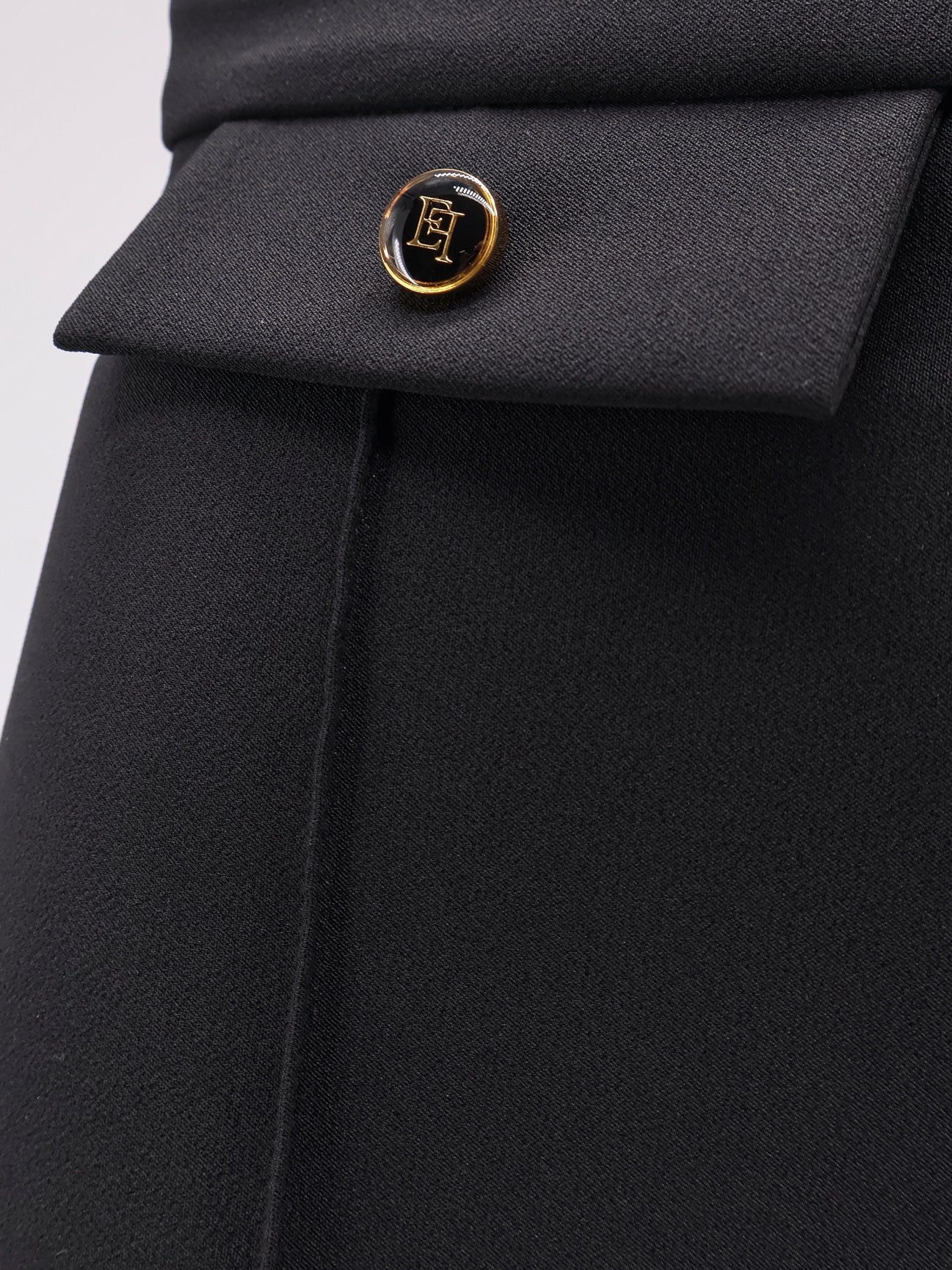 Trousers with double logoed button