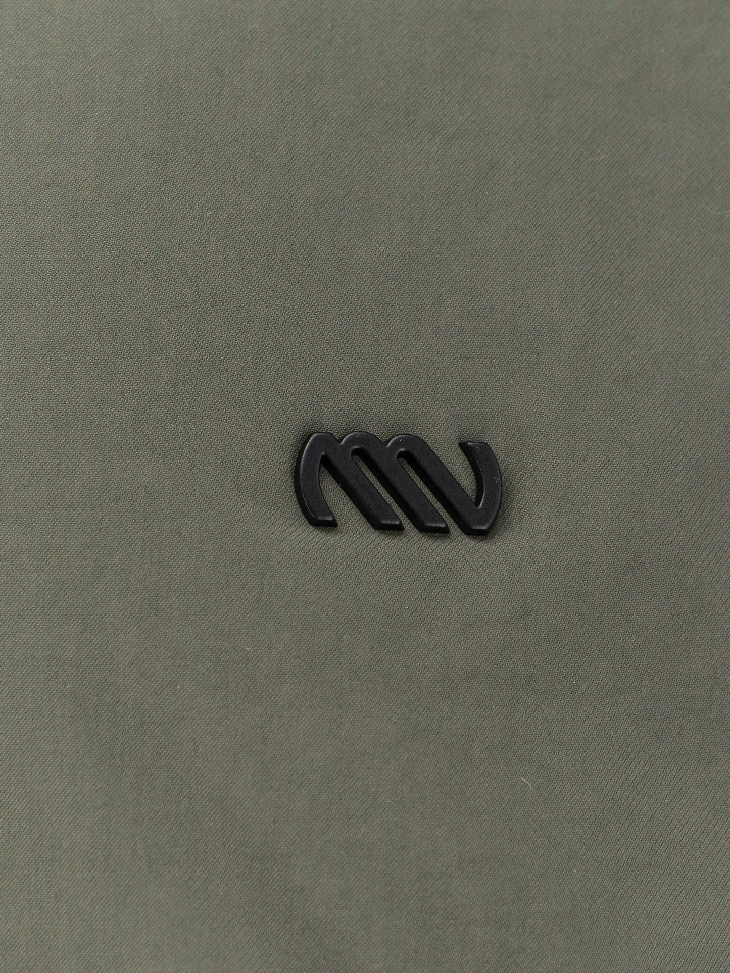 Nylon jacket with metal logo patch on the front