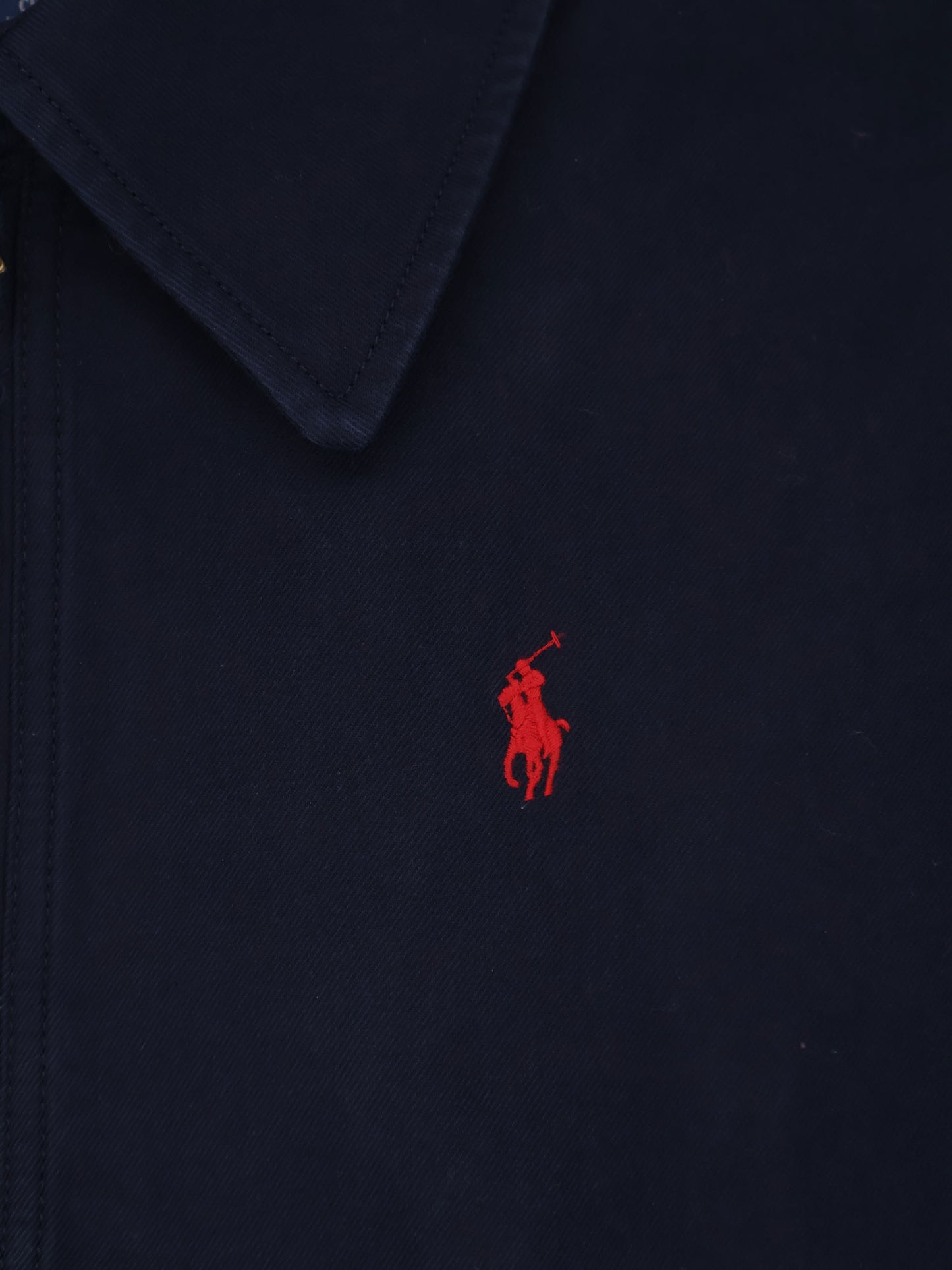 Blue denim jacket with embroidered logo on the front