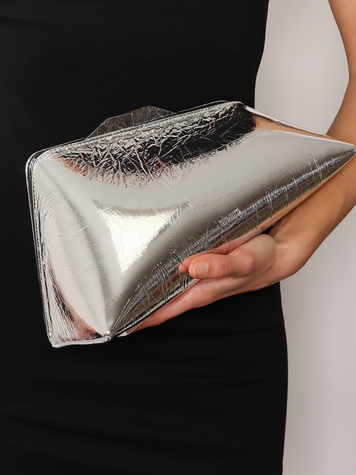 8.30 PM laminated leather clutch bag with logo engraved on the bottom